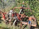 un tracteur qui est garé dans l'herbe près d'une clôture