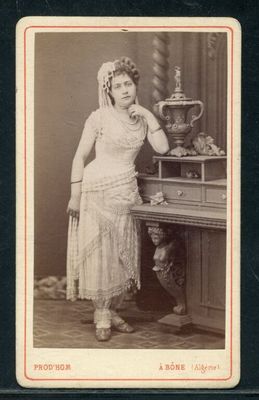 une vieille photo d'une femme debout devant une table