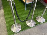 three metal poles that are on the grass near a shelf
