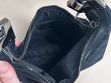 a person holding a black purse with a lighter in it