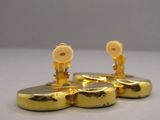 three gold buttons on top of each other on a white surface