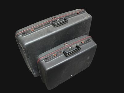 deux bagages posés l'un à côté de l'autre sur un fond noir