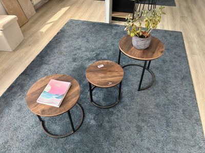 trois tables posées sur un tapis dans un salon