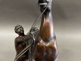 bronze statue of a man on a horse with a man on the back