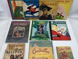 several children ' s books are lined up on a white surface