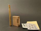 a gold lighter and a packet of cigarettes on a table