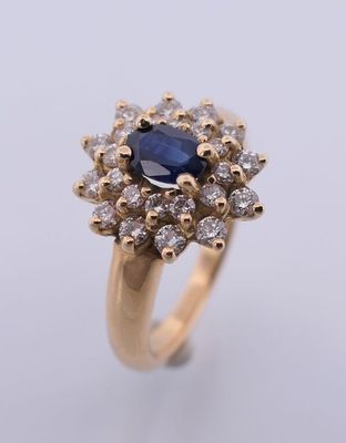 un gros plan d'une bague en or sertie d'un saphir bleu et de diamants blancs