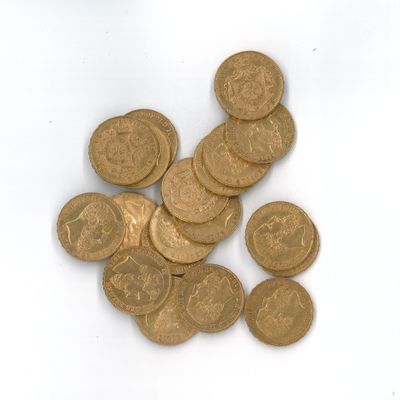 une pile de pièces d'or posée sur une surface blanche