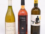 trois bouteilles de vin posées l'une à côté de l'autre sur une table
