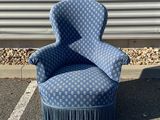 une chaise bleue posée au milieu d'un parking