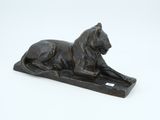 statue of a lion on a base on a white surface