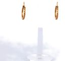 une paire de boucles d'oreilles créoles en or sur fond blanc