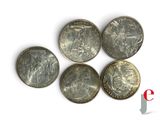 six different british coins sitting on top of each other on a white surface