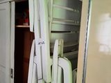 a stack of refrigerators in a room with a bed on top of it