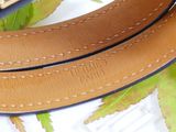 a brown belt with a gold buckle on a white surface