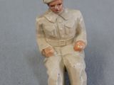 toy figurine of a man sitting on a chair
