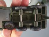 a person holding a toy army vehicle in their hand
