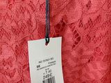 red lace dress with a price tag on it hanging on a hanger