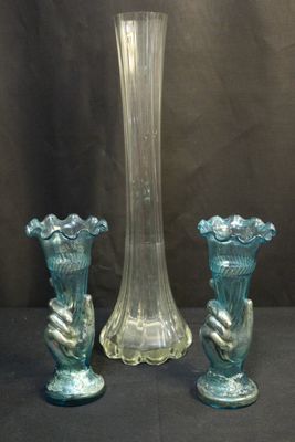 trois vases en verre posés l'un à côté de l'autre sur une table