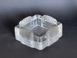 an image of a clear glass ashtray on a black surface