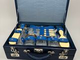 une valise bleue contenant des outils, posée sur une surface blanche