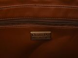 the inside of a brown purse with a metal tag on it