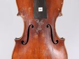 an old violin hanging from the back of a white wall