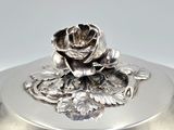 a silver plate with a rose on it on a table