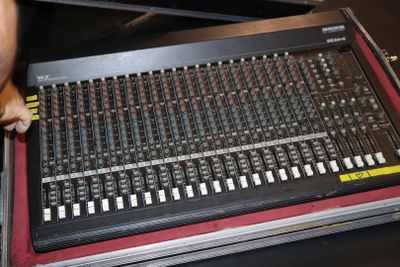 un homme debout à côté d'une table de mixage