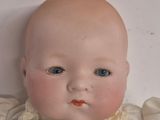 a baby doll that is laying down on a white surface