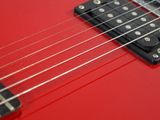 an image of a red electric guitar sitting on top of a white surface