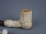 a pipe that is sitting on a table next to a flower