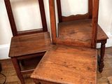 two wooden chairs sitting next to each other on a hard wood floor