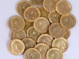 a pile of gold coins sitting on a white surface