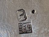 a silver plate with a metal stamp on it