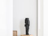 une sculpture noire posée sur une caisse en bois