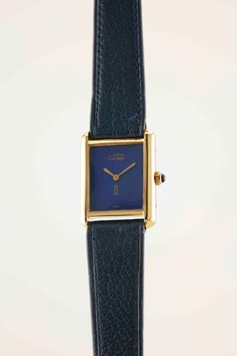 a close up of a watch with a blue face on a black strap