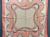 a pink and blue handkerchief hanging on a wall