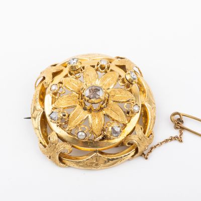 une image représentant une broche en or entourée d'une chaîne