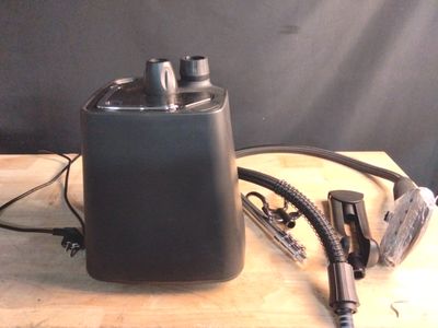 une photo d'une enceinte noire posée sur une table en bois