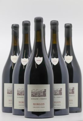 six bouteilles de vin sont alignées sur une surface blanche