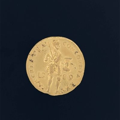 a close up of a gold coin on a black surface