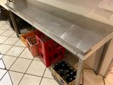 a stainless steel table with a bunch of bottles on it