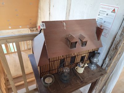 une maison de poupées posée sur une table dans une pièce en cours de construction