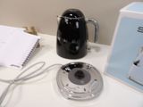 a black coffee pot sitting on a counter next to a notepad