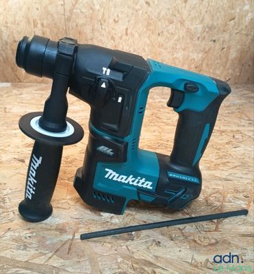 une perceuse et un marteau posés sur un plancher en bois