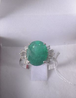 a picture of a ring with a green stone in it