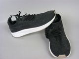 pair of black sneakers with white soles on a white surface