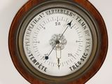 a wooden clock with a barometer on it ' s face