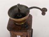 an old coffee grinder sitting on top of a wooden table